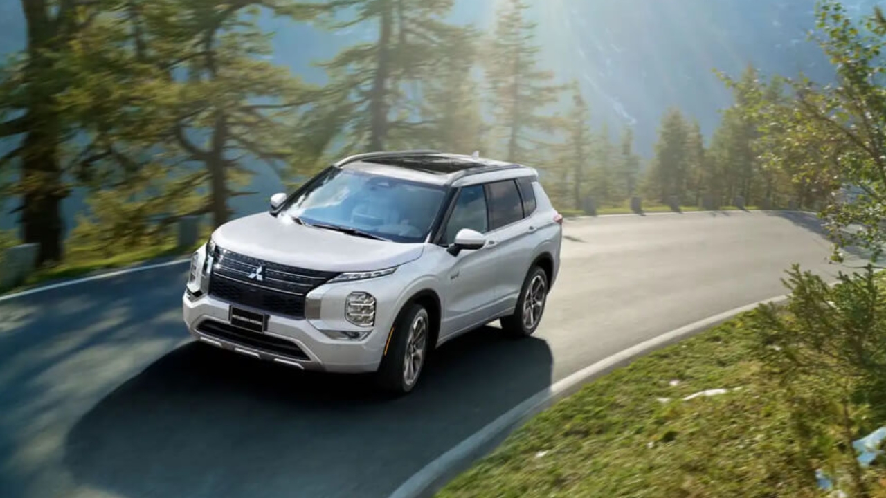 vue latérale avant d'une Mitsubishi Outlander 2024 sur une route de campagne