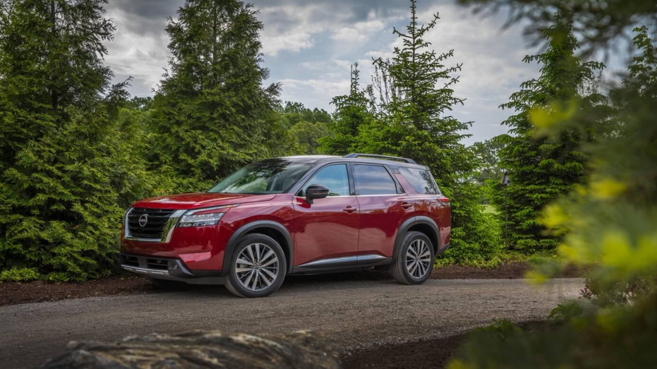 vue latérale avant d'une Nissan Pathfinder 2024 sur un sentier en forêt