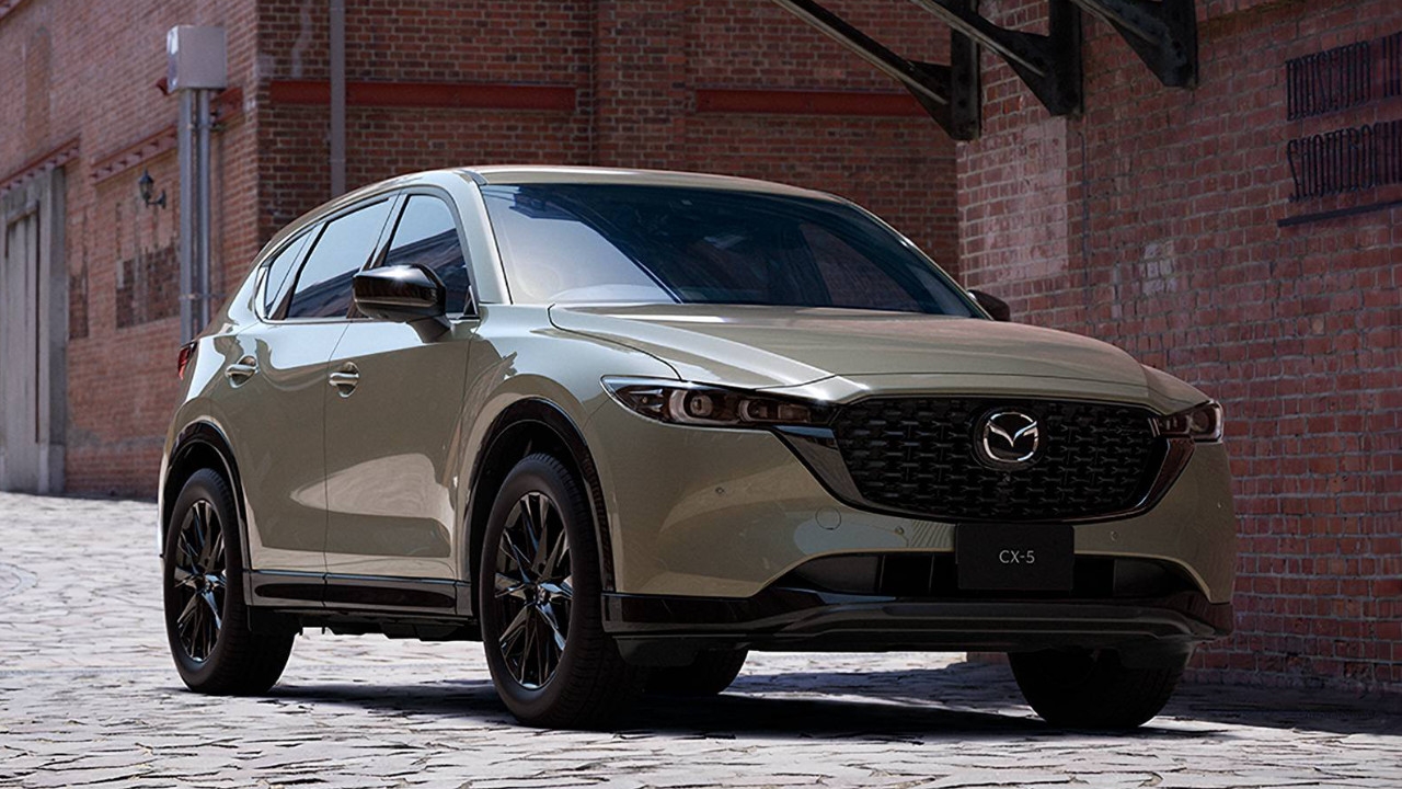 vue latérale avant d'un Mazda CX-5 devant un bâtiment en briques