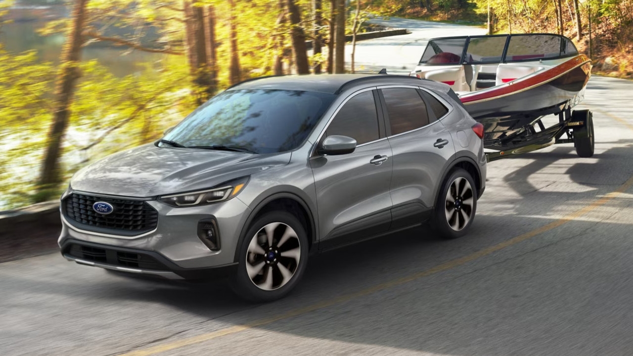 vue latérale avant d'un Ford Escape 2024 remorquant un bateau sur une route de campagne