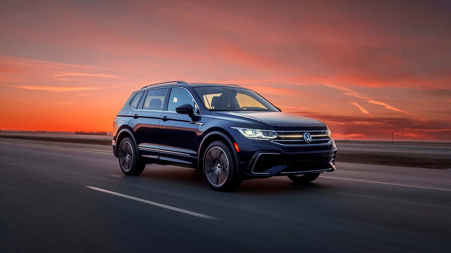 vue latérale avant d'un VW Tiguan 2024 sur une route au crépuscule