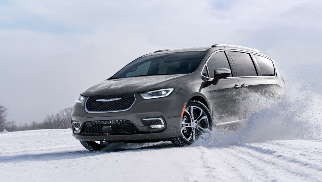 vue latérale avant d'une Chrysler Pacifica 2024 sur un terrain enneigé