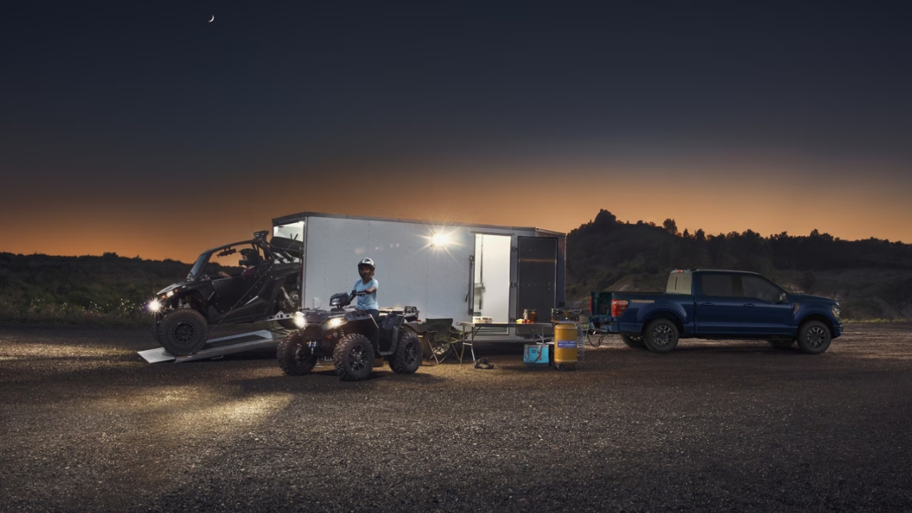 Ford F-150 2025 le soir, trainant une avec des VTT
