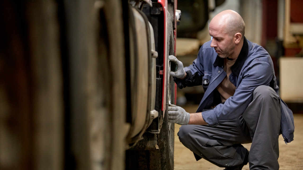 personne en train d'inspecter les pneus d'un véhicule